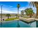 Inviting pool area with putting green, lush palms, and city views in backyard at 156 N Parawan St, Henderson, NV 89015