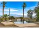 Backyard with pool, city views, and lush palms in this beautiful outdoor space at 156 N Parawan St, Henderson, NV 89015