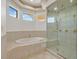 This bathroom features tile flooring, a tub under the window, and a glass enclosed shower with jets at 156 N Parawan St, Henderson, NV 89015
