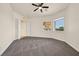 This bedroom features two windows, a ceiling fan, and a door that leads to another room at 156 N Parawan St, Henderson, NV 89015