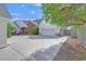 Exterior of home with brick and white accents, a large driveway, and mature landscaping at 156 N Parawan St, Henderson, NV 89015