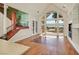 Bright living room with large windows, wood floors, and staircase at 156 N Parawan St, Henderson, NV 89015