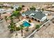 Backyard oasis featuring a sparkling pool, green turf area, and lush palm trees perfect for outdoor living at 156 N Parawan St, Henderson, NV 89015
