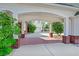 Portico entrance featuring brick columns, lush greenery, and a glimpse of the garage, showcasing the architectural details at 156 N Parawan St, Henderson, NV 89015