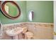 Quaint powder room with tiled walls and a pedestal sink at 156 N Parawan St, Henderson, NV 89015