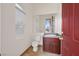 Cozy powder room with a wood vanity, modern fixtures, and natural light at 156 N Parawan St, Henderson, NV 89015