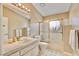 Traditional bathroom featuring tile floors, a white tiled countertop, and a bathtub with gold sliding glass doors at 1970 Del Font Ct, Las Vegas, NV 89117