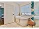 Bright bathroom with a modern tub, stylish tile, and natural light from the window at 1970 Del Font Ct, Las Vegas, NV 89117