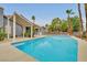 This backyard features a pool, covered patio, palm trees, and ample seating at 1970 Del Font Ct, Las Vegas, NV 89117