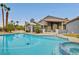 Backyard oasis featuring a sparkling pool, mature palm trees, covered patio, and spa at 1970 Del Font Ct, Las Vegas, NV 89117