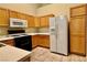 The kitchen features wooden cabinets, white countertops, and modern appliances for a functional cooking space at 2000 Gravel Hill St # 203, Las Vegas, NV 89117