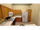 A functional kitchen includes wooden cabinets, white countertops, microwave, and an electric range at 2000 Gravel Hill St # 203, Las Vegas, NV 89117