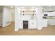 Stylish bar area with floating shelves, wine cooler, and white shaker cabinets with brass hardware at 2107 Fountain Springs Dr, Henderson, NV 89074