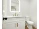 Stylish half-bathroom with a backlit mirror, white vanity, and a modern gold faucet at 2107 Fountain Springs Dr, Henderson, NV 89074