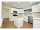 Modern kitchen with white cabinets, stainless steel appliances, light countertops and wood floors at 2107 Fountain Springs Dr, Henderson, NV 89074