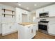 Open-concept kitchen with stainless steel oven and microwave, butcher block island, and modern white cabinets at 2107 Fountain Springs Dr, Henderson, NV 89074