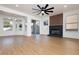 Bright living room with wood floors, a modern ceiling fan, and a fireplace with a dark brick surround at 2107 Fountain Springs Dr, Henderson, NV 89074
