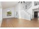 Bright open-concept living space featuring wood-look floors, vaulted ceilings, and staircase leading to the upper level at 2107 Fountain Springs Dr, Henderson, NV 89074