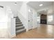 Carpeted staircase leading to the upper level, open to the living area with wood-look flooring and a fireplace visible at 2107 Fountain Springs Dr, Henderson, NV 89074