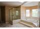 Bathroom featuring a glass-enclosed shower and soaking tub with tile surround at 2208 Fiero Dr, Las Vegas, NV 89134