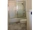 Bathroom featuring a toilet, shower and tub combination, sliding glass door, and marble floors at 2208 Fiero Dr, Las Vegas, NV 89134