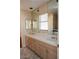 Bathroom featuring dual sinks, tile countertops, vanity mirrors, and storage cabinets at 2208 Fiero Dr, Las Vegas, NV 89134