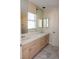 Bathroom featuring dual sinks, tile countertops, vanity mirrors, and storage cabinets at 2208 Fiero Dr, Las Vegas, NV 89134