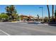 Gated community entrance featuring manicured landscaping, palm trees, and exterior lighting at 2208 Fiero Dr, Las Vegas, NV 89134