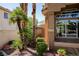 Close-up view of exterior landscaping, including palm trees, shrubs, and rock features near the home at 2208 Fiero Dr, Las Vegas, NV 89134