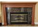 Close-up of a fireplace with a dark marble surround and wooden mantel at 2208 Fiero Dr, Las Vegas, NV 89134