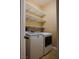 Well-equipped laundry room with a washer, a dryer, and white shelving for storage at 2208 Fiero Dr, Las Vegas, NV 89134