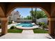 View of backyard pool and spa surrounded by lush landscaping, as seen from a covered area at 2208 Fiero Dr, Las Vegas, NV 89134