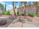 Paver patio and retaining wall with mature trees provides privacy in this backyard space at 2417 Chestnut Hill St, Las Vegas, NV 89134