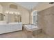 Bathroom featuring a glass shower, soaker tub, double sinks and travertine tile at 2417 Chestnut Hill St, Las Vegas, NV 89134