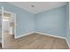 Bedroom painted in a light blue with wood floors, white trim and an open door to bathroom at 2417 Chestnut Hill St, Las Vegas, NV 89134