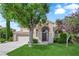 Inviting two-story home with an arched entryway, lush green lawn, and a spacious three car garage at 2417 Chestnut Hill St, Las Vegas, NV 89134