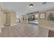 Open-concept living room with tile floors, sliding glass doors to the backyard, and an open view to the kitchen at 2417 Chestnut Hill St, Las Vegas, NV 89134