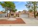 Inviting single-story home with a two-car garage and meticulously landscaped front yard, complete with mature shade trees at 2430 Sungold Dr, Las Vegas, NV 89134