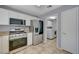 Well-lit kitchen featuring stainless steel appliances, granite countertops, and access to the laundry room at 2430 Sungold Dr, Las Vegas, NV 89134