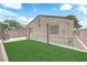 Home's backyard featuring green turf, a concrete border, and a beige exterior at 2432 Shady Hill Ave, Las Vegas, NV 89106