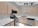 Modern kitchen featuring stainless steel appliances, tile flooring, bright lighting, and functional layout at 2432 Shady Hill Ave, Las Vegas, NV 89106