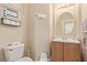 Cozy half bathroom featuring neutral walls, oval mirror, and dark wood vanity at 2621 Rainbow Glow St, North Las Vegas, NV 89030