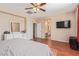 Bedroom featuring hard wood floors, a ceiling fan, a bed and dresser at 2621 Rainbow Glow St, North Las Vegas, NV 89030