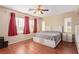 Spacious bedroom with a ceiling fan, modern bed, and rich wood-look floors at 2621 Rainbow Glow St, North Las Vegas, NV 89030