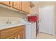 This bright laundry room features a washer, dryer, sink and upper cabinetry at 2621 Rainbow Glow St, North Las Vegas, NV 89030