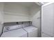 Functional laundry room with side by side washer and dryer, upper shelving for storage and a white shutter door at 2761 Carnation Ln # 1, Henderson, NV 89074