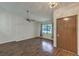 Bright living area featuring wood-look floors, a ceiling fan, a window with natural light, and a brown door at 2761 Carnation Ln # 1, Henderson, NV 89074