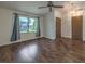 Spacious living area with wood floors, a ceiling fan, natural light, and two paneled doors at 2761 Carnation Ln # 1, Henderson, NV 89074