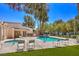 Relaxing community pool area featuring a clear blue pool, comfortable lounge chairs, and lush palm trees at 2761 Carnation Ln # 1, Henderson, NV 89074