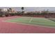 Well-maintained tennis court with red and green surface, surrounded by a fence and neighborhood homes at 2761 Carnation Ln # 1, Henderson, NV 89074
